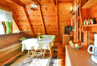 Gezellige houten lodge met eettafel, zetel en natuurlijk licht in Osieki, Denemarken.