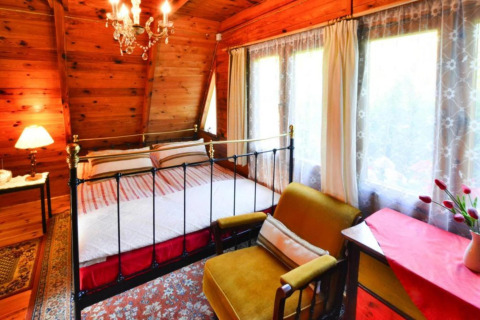 Hyggeligt soveværelse i træ med dobbeltseng, gyngestol og store vinduer i Summer Cottage 70 m2 TYPE B Osieki.