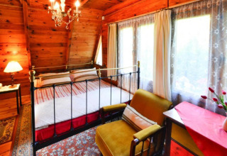 Hyggeligt soveværelse i træ med dobbeltseng, gyngestol og store vinduer i Summer Cottage 70 m2 TYPE B Osieki.