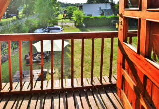 Uitzicht vanaf het balkon van Summer cottage 70 m2 TYPE B Osieki in Denemarken, tuin en auto zichtbaar.
