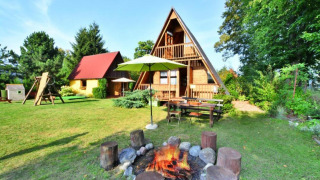 Sommerhaus 70 m2 TYP B Osieki mit A-förmigem Dach, Lagerfeuerstelle und grüner Garten im Freien.