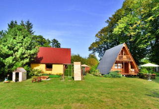 Summer cottage 70 m2 TYPE B Osieki in Denmark featuring A-frame wooden cabin, yellow house and garden.