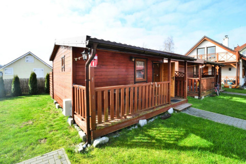 Single-storey wooden cottage, 30 m2, TYPE B in Ustronie Morskie with front porch and green yard.