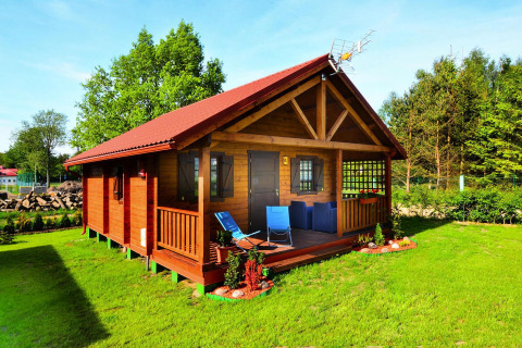 Summer cottage for 5 people on Górna Ustronie Morskie with a porch, deck chairs, and lush green lawn.
