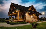 Blokhut bij Highlander cottages ZUMAR Wicie in Denemarken, met tuin en bloemen in de avondschemer.