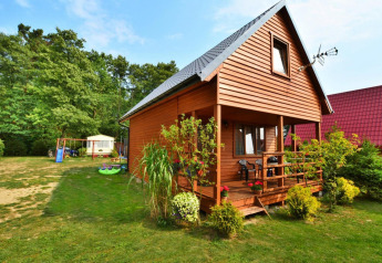 Gemütliche Holzhütte von Domek 5-osobowy Jarosławiec mit Garten, Terrasse und Spielplatz im Grünen.