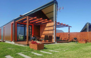 Lodge de vacances moderne à Domki wakacyjne Jezierzany au Danemark, avec terrasse, jardin et ciel bleu.