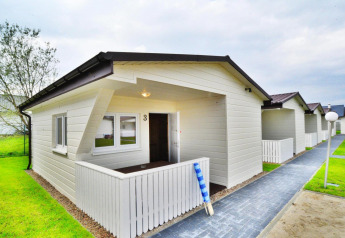 Witte vakantiewoningen bij Domki wakacyjne Przewłoka met nette gazons en aangelegde paadjes.