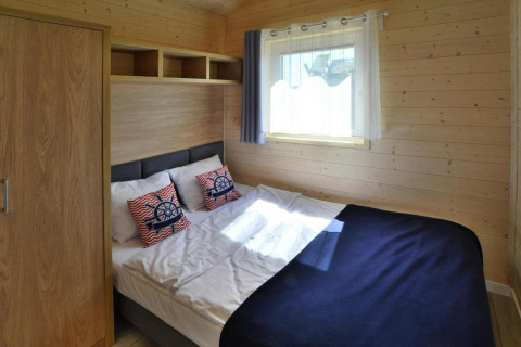 Chambre chaleureuse dans les Single-storey holiday cottages Sarbinowo au Danemark avec lit et fenêtre lumineuse.