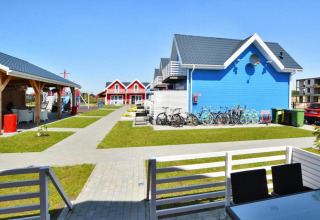 Casas de vacaciones coloridas en Sarbinowo, Dinamarca, con bicicletas, terraza y parque infantil cercano.