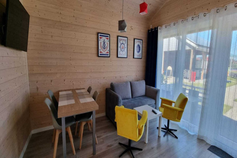 Salon du lodge Single-storey holiday cottages Sarbinowo au Danemark, avec murs en bois et mobilier coloré.
