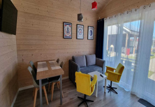 Salón del alojamiento Single-storey holiday cottages Sarbinowo en Dinamarca, con paredes de madera y muebles modernos.