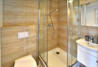 Moderne badkamer met douche, toilet en lavabo in lodge bij Single-storey holiday cottages Sarbinowo, Denemarken.