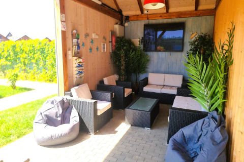 Loungehoek bij Single-storey holiday cottages Sarbinowo met loungebanken, zitzakken en groene planten.