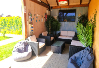 Zona lounge en Single-storey holiday cottages Sarbinowo, Dinamarca, con sofás, puff y plantas decorativas.
