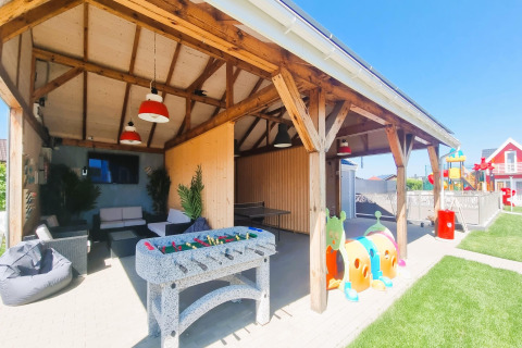 Espace lounge couvert de Single-storey holiday cottages Sarbinowo avec baby-foot, canapés et aire de jeux.