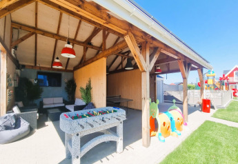 Zona exterior en Single-storey holiday cottages Sarbinowo con futbolín, sofás y área de juegos infantiles.