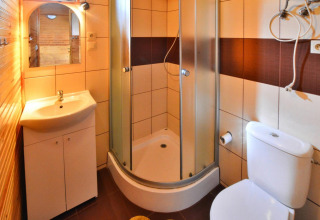 Badkamer in een gelijkvloerse vakantiewoning met douche, lavabo en toilet in Ustronie Morskie, Denemarken.