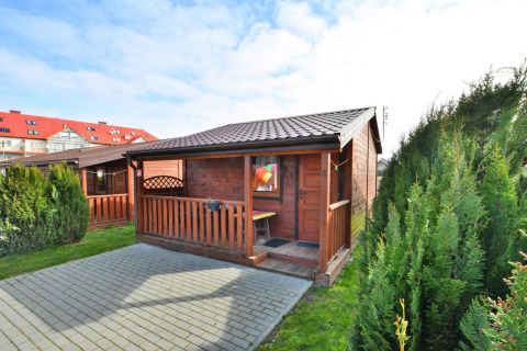 Eénverdieping houten chalet van 30 m2 met terras en struiken in Ustronie Morskie, Denemarken.