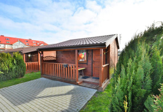 Eénverdieping houten chalet van 30 m2 met terras en struiken in Ustronie Morskie, Denemarken.