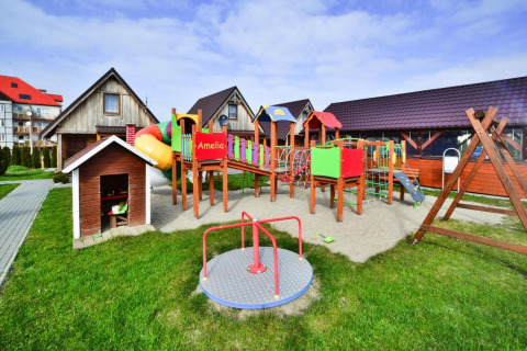 Playground with slide and cottages at Older year-round cottage TYPE A Ustronie Morskie in Denmark.
