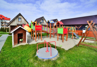 Playground with slide and cottages at Older year-round cottage TYPE A Ustronie Morskie in Denmark.