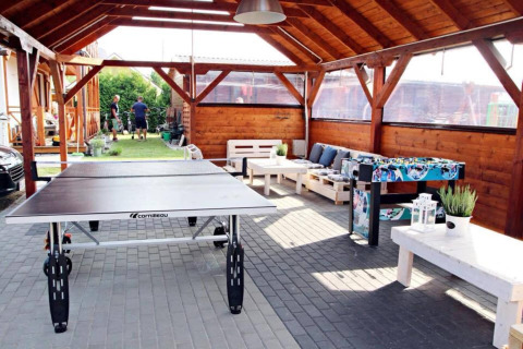 Overdekte ontspanningsruimte aan Older year-round cottage TYPE A Ustronie Morskie met pingpong en zitbank.