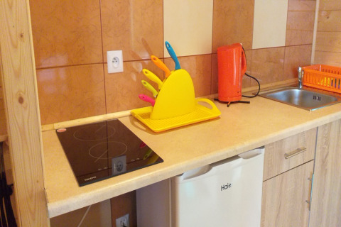 Moderne chaletkeuken met oranje waterkoker en kleurrijke messen in Sarbinowo, Denemarken.