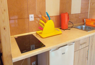 Moderne chaletkeuken met oranje waterkoker en kleurrijke messen in Sarbinowo, Denemarken.