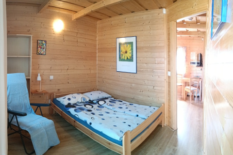 Gezellige slaapkamer in een houten huisje bij Holiday cottages Sarbinowo, Denemarken, met tweepersoonsbed.