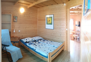 Camera accogliente di legno presso Holiday cottages Sarbinowo, Danimarca, con letto matrimoniale.