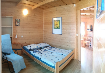 Camera accogliente di legno presso Holiday cottages Sarbinowo, Danimarca, con letto matrimoniale.