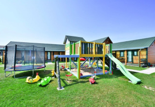 Speeltuin met schommels, glijbaan en trampoline voor de chalets van Holiday cottages Sarbinowo in Denemarken.