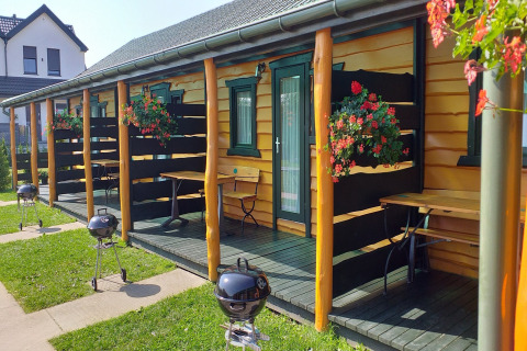 Vakantiehuisjes te Sarbinowo met privéterrassen, bloemen en barbecues, zonnige dag in Denemarken.