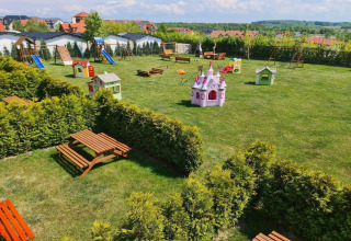 Speelplaats met glijbanen, schommels en speelhuizen bij huisjes in Jarosławiec, Denemarken.