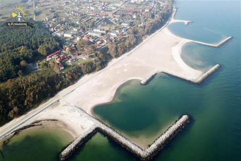 Aerial view of the beach and Single-storey cottages Jarosławiec in Jarosławiec, Denmark, with breakwaters.