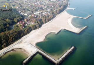 Luchtfoto van het strand en Single-storey cottages Jarosławiec in Jarosławiec, Denemarken met golfbrekers.