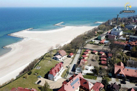 Luchtfoto van strand, zee en huisjes in Jarosławiec bij de kust, niet in Denemarken, met zandstrand.