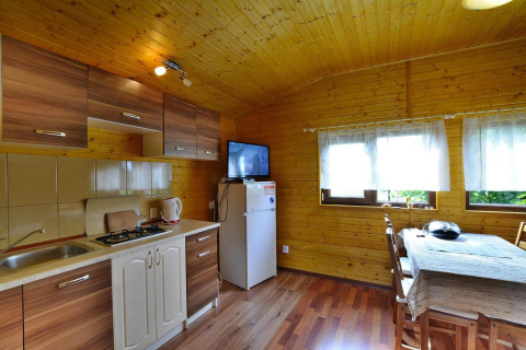 Binnenaanzicht van de keuken en eethoek in een houten vakantiehuis Holiday cottage Rusinowo, Denemarken.