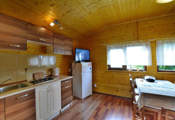 Vista interior de la cocina y comedor en una cabaña de madera en Holiday cottage Rusinowo, Dinamarca.
