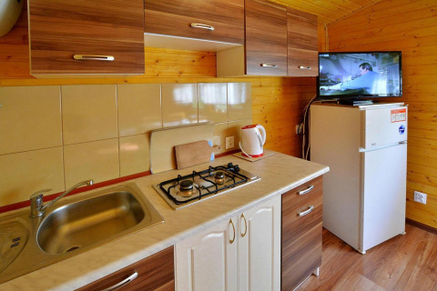 Cocina moderna en la cabaña Holiday cottage Rusinowo, Dinamarca, con estufa, fregadero y nevera.