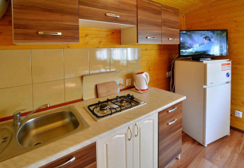Cocina moderna en la cabaña Holiday cottage Rusinowo, Dinamarca, con estufa, fregadero y nevera.
