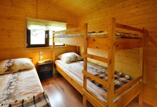Træværelse i Holiday cottage Rusinowo med køjeseng, enkeltseng, natbord og vindue i Danmark.