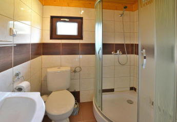 Baño luminoso en Holiday cottage Rusinowo con ducha, inodoro y pequeña ventana, Dinamarca.