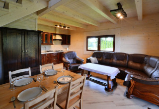 Gezellige lodge in Denemarken met houten eetruimte, leren salon, open keuken en een grote kleerkast.