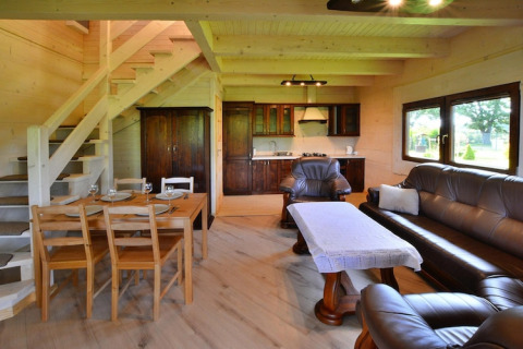 Woon- en keukenruimte bij Highlander cottages ZUMAR Wicie, houten interieur, eettafel en sofa.