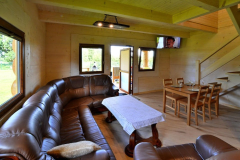 Interieur van Highlander cottages ZUMAR Wicie in Denemarken met leren zetel, eettafel en trap