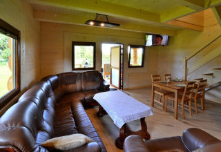 Interieur van Highlander cottages ZUMAR Wicie in Denemarken met leren zetel, eettafel en trap