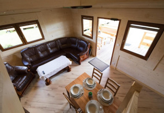 Living and dining room at Highlander cottages ZUMAR Wicie with leather sofa and table, Denmark.