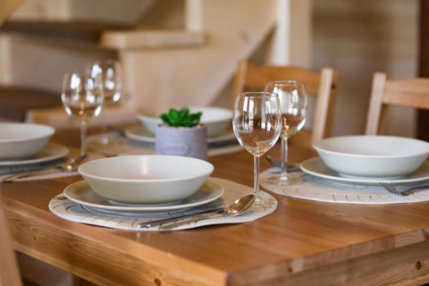 Gedekte tafel voor vier personen in Highlander cottages ZUMAR Wicie, Denemarken, met glazen en borden.